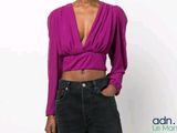 woman wearing a purple top and black jeans posing for a picture