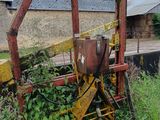 un tracteur qui est garé dans l'herbe près d'un bâtiment