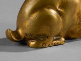 a gold pig figurine sitting on a gray surface