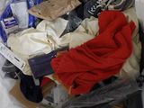 a bag full of clothes and other items on a bed