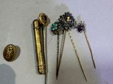 a small collection of hair pins and brooches on a table
