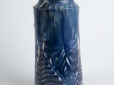 a blue vase that is sitting on a white surface