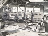 black and white photo of a group of men working on a plane