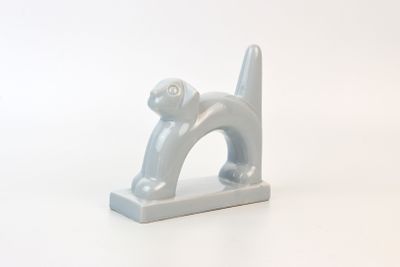 a gray cat figurine sitting on a white surface