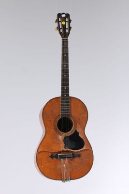 an old wooden guitar hanging from the ceiling in a room