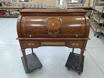 un petit bureau en bois sur lequel est posée une horloge