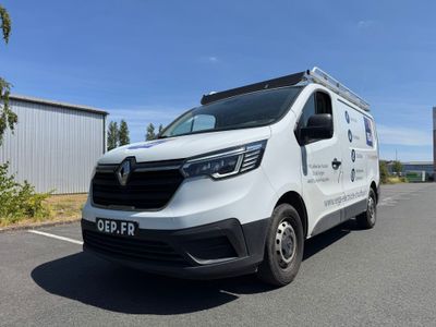 une camionnette blanche garée sur un parking à côté d'un bâtiment
