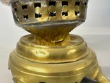 a gold colored lamp that is on top of a table