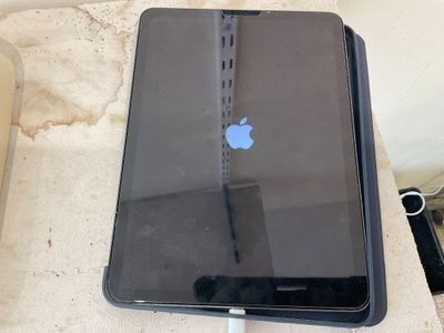 un iPad d'Apple posé sur une table avec un chargeur