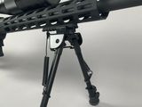 a close up of a rifle on a tripod on a white background