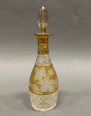 a glass bottle with a gold decoration on it