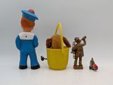 toy figurines of a man with a basket and a teddy bear in a basket