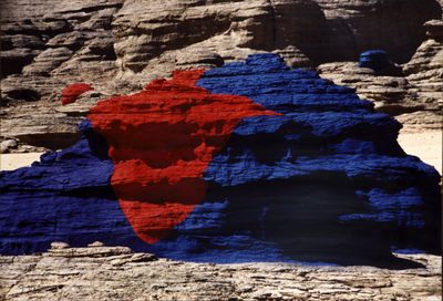 une image représentant un drapeau rouge et bleu posé sur un rocher