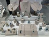 many necklaces and bracelets displayed on display in a glass case