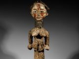 une statue en bois représentant une femme tenant un bébé dans ses bras