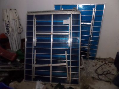 une pile de boîtes bleues et un rayonnage métallique dans une pièce