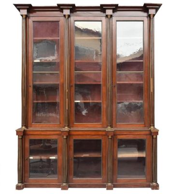 une bibliothèque ancienne en bois, avec des portes vitrées et des étagères