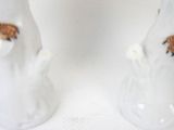 two figurines of a man and a woman holding hands
