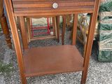 a small table with a drawer on it in the middle of a pile of furniture