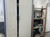 a cabinet in a garage with a door open