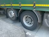a green and yellow truck parked on the side of the road
