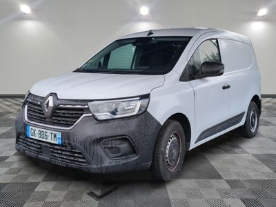 la camionnette blanche est garée sur le sol en damier d'un garage
