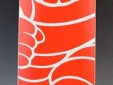 une image représentant un vase en verre rouge orné de motifs blancs