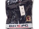 the black shirt is wrapped in plastic and has a badge on it