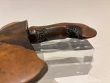 a wooden knife that is on display on a glass table