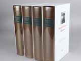 three books in a white box on a gray surface