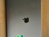 an apple laptop with a sticker on it sitting on a wooden table