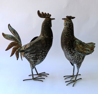 deux poulets en métal placés côte à côte sur une surface blanche
