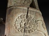 a wooden carving of a bird with a flower on it