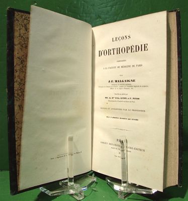 un livre ouvert posé sur une table, avec un porte-verre à côté