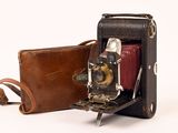 un étui en cuir marron contenant un appareil photo et un sac marron