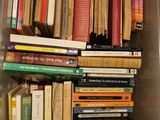 a plastic container filled with books on top of a table
