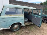 an old blue van with its door open in front of a building