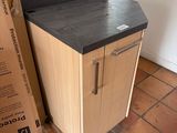 a small kitchen with a black counter top next to a cardboard box