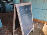 a chalk board with writing on it in front of a store