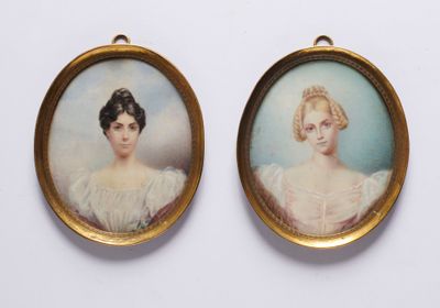 Deux portraits miniatures représentant une femme et un homme sont présentés dans un cadre doré.