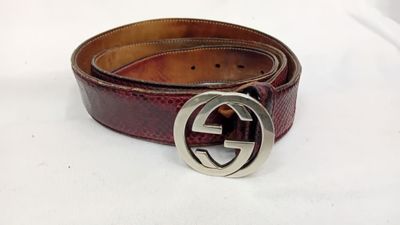 un gros plan d'une ceinture marron avec une boucle argentée