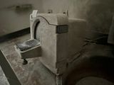 a dirty bathroom with a toilet and a sink in it