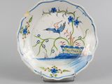 l'image d'une assiette bleue et blanche sur laquelle figure un oiseau