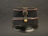 un chapeau noir orné d'un bouton doré