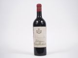 une bouteille de vin rouge posée sur une table blanche