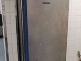 a silver refrigerator in the middle of a blue floor