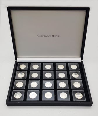 a black box filled with silver coins sitting on top of a white table