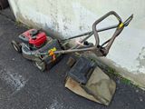 a lawn mower that is laying on the ground next to a wall
