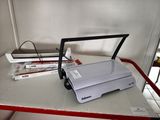 a white printer sitting on a table next to a stack of books
