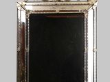 an image of a silver framed mirror on a gray wall